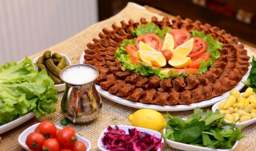 Yeşillik, limon ve turşuyla sunulan çiğ köfte tabağı